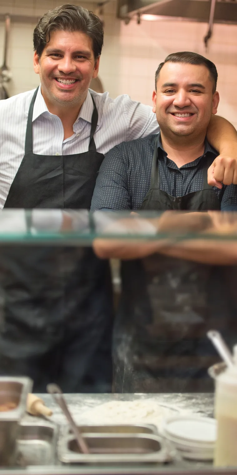 Two pizzeria owners in their kitchen
